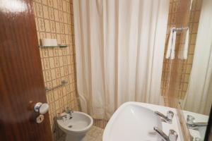 a bathroom with a toilet and a tub and a sink at Residencial Campo-Mar by Umbral in Portimão