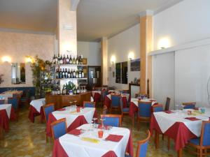 a restaurant with white tables and chairs and wine bottles at Albergo La Vela in Rapallo