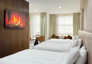 two beds in a hotel room with a fire on the wall at Central Sweet Stay in Tangier