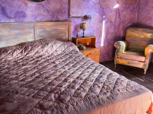 ein Schlafzimmer mit einem großen Bett und einem Stuhl in der Unterkunft Paciu Maison - Dimora Artistica Immersiva in Ozzano dell’Emilia