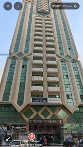 a tall building with a sign on the side of it at ALEX Hostel - Bed in a shared room - C504 in Sharjah