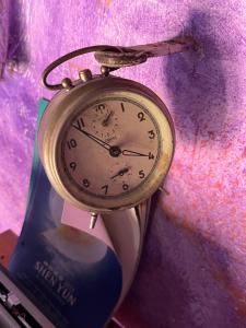 eine goldene Uhr hängt an einer violetten Wand in der Unterkunft Paciu Maison - Dimora Artistica Immersiva in Ozzano dell’Emilia