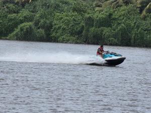 a man riding a speed boat in the water at Noeline Villa in Bentota