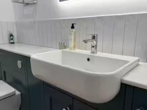 a white bathroom sink with a soap bottle on it at Old Library Apartments - 8a in Orkney +5 photos