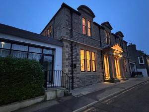 a brick house on a street with its lights on at Old Library Apartments - 8a in Orkney