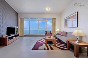 a living room with a couch and a tv at The Curve Hotel in Doha