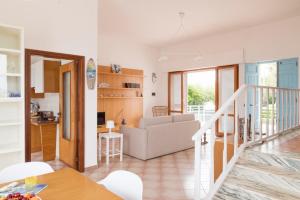 a living room and kitchen with a couch and a table at Villa Elvira - Apulian Stay Group in Faccia di Trippa