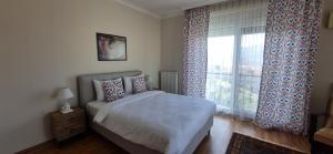 a bedroom with a bed and a window with curtains at Ephesus Suites in Selçuk