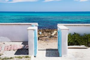 a gate to the beach with the ocean in the background at Villa Elvira - Apulian Stay Group in Faccia di Trippa