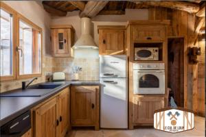 a kitchen with a white refrigerator and wooden cabinets at Domaine du Pays de Chambord, l'insolite Cul de Loup ou la traditionnelle Bédinière à 5 minutes de Chambord in Crouy-sur-Cosson