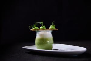 a glass jar with a green drink on a plate at Haubers Naturresort in Oberstaufen