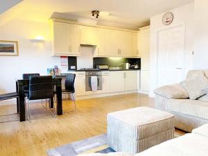 a living room with a table and a kitchen at Harbour Penthouse Whitby in Whitby