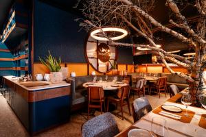 a restaurant with tables and chairs and a tree at Axis Porto Club Aliados in Porto