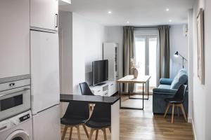 a kitchen and living room with a table and chairs at Apartamentos Ciudad del Cava in Almendralejo