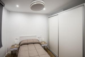 a bedroom with a bed and two night stands at Apartamentos Ciudad del Cava in Almendralejo