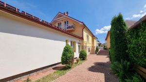 a walkway between two houses with bushes at Vila Adria in Hrabušice
