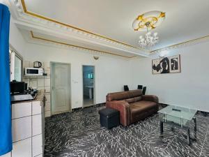 a living room with a couch and a table at CAMERHOME Carrefour mosqué Cité des palmiers in Douala