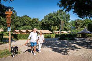 a man and woman walking a dog on a leash at Gooise Heide in Huizen