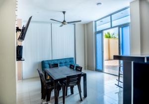 a dining room with a table and a blue couch at Cabanas Villa Antonella Covenas in Coveñas