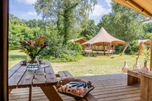 a wooden deck with a table with a vase of flowers at Gooise Heide in Huizen
