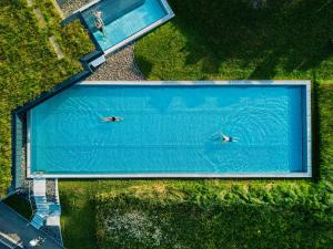 two people swimming in a large swimming pool at Haubers Naturresort in Oberstaufen