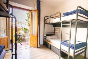 a room with three bunk beds and a balcony at Ostello Bello Firenze in Florence