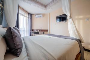 a bedroom with a large white bed with a window at Divine Homes Resort Kisumu in Kisumu