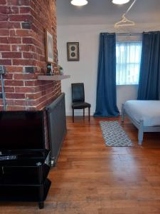 a living room with a bed and a brick wall at Number Four in Brighton & Hove