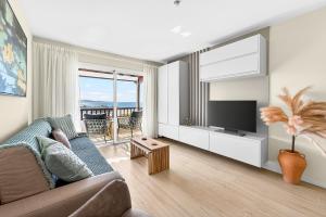 a living room with a couch and a flat screen tv at Seaview Oasis Luxury Duplex La Caleta in Adeje