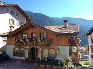 a house with a balcony with flowers on it at Appartamenti -Casa Nicolussi- in Molveno