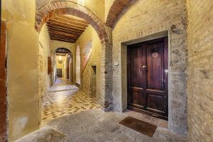 an alley way with a wooden door in a building at Ele Home in Siena