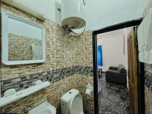 a bathroom with a toilet and a mirror on the wall at CAMERHOME Carrefour mosqué Cité des palmiers in Douala