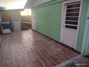 an empty patio with a green wall and a door at Casa 2 Quartos - Vila Real in Chapecó