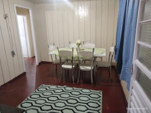 a dining room with a table with chairs and a table and a table and chairs at Casa 2 Quartos - Vila Real in Chapecó +6 photos