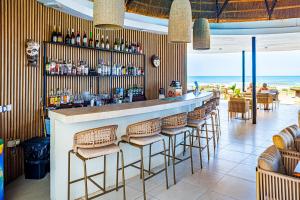 a bar with a row of bar stools in a restaurant at Kombo Beach Resort in Serekunda +37 photos