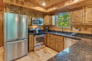 a kitchen with a stainless steel refrigerator and wooden cabinets at Smoky Elk in Whittier