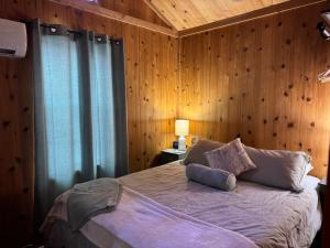 a bedroom with a bed with a wooden wall at Quiet Mountain Top, Pet Friendly, Private Deck in Boone