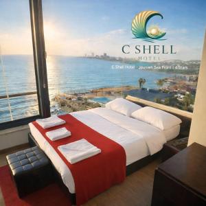 una camera da letto con un grande letto e vista sull'oceano di C Shell Hotel a Jounieh