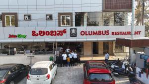 a group of people standing in front of a restaurant at CSK Comforts in Tumkūr