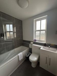 a bathroom with a tub and a toilet and a sink at Feildens Arms Hotel in Blackburn +52 photos