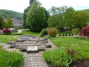 a stone pathway in a garden with grass and trees at Ferienwohnung Neifer in Bad Überkingen