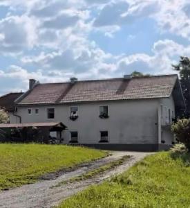 a large white house with a dirt road at Im Grünen in Katzbach
