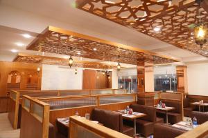 a restaurant with tables and chairs and a bar at CSK Comforts in Tumkūr