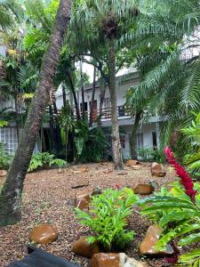 a garden in front of a house with palm trees at Suíte aconchegante beira mar - Suíte 255 in Guarujá