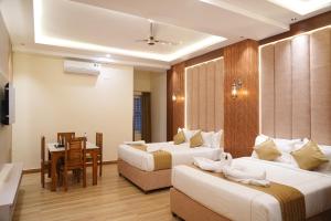 a hotel room with two beds and a table at CSK Comforts in Tumkūr