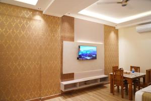 a living room with a television on a wall at CSK Comforts in Tumkūr