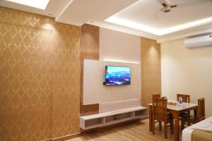 a living room with a television on a wall at CSK Comforts in Tumkūr +10 photos