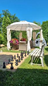 a chess board and a bench in a garden with a canopy at Vila Adria in Hrabušice