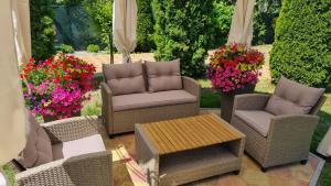 a patio with chairs and a table and flowers at Vila Adria in Hrabušice