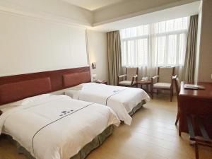 a hotel room with two beds and a desk at Shenzhen Xingwei Yifeng Hotel in Shenzhen +9 photos